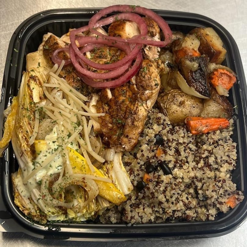 Tasha's soul food meal with chicken, roasted vegetables, quinoa, and pickled red onions.